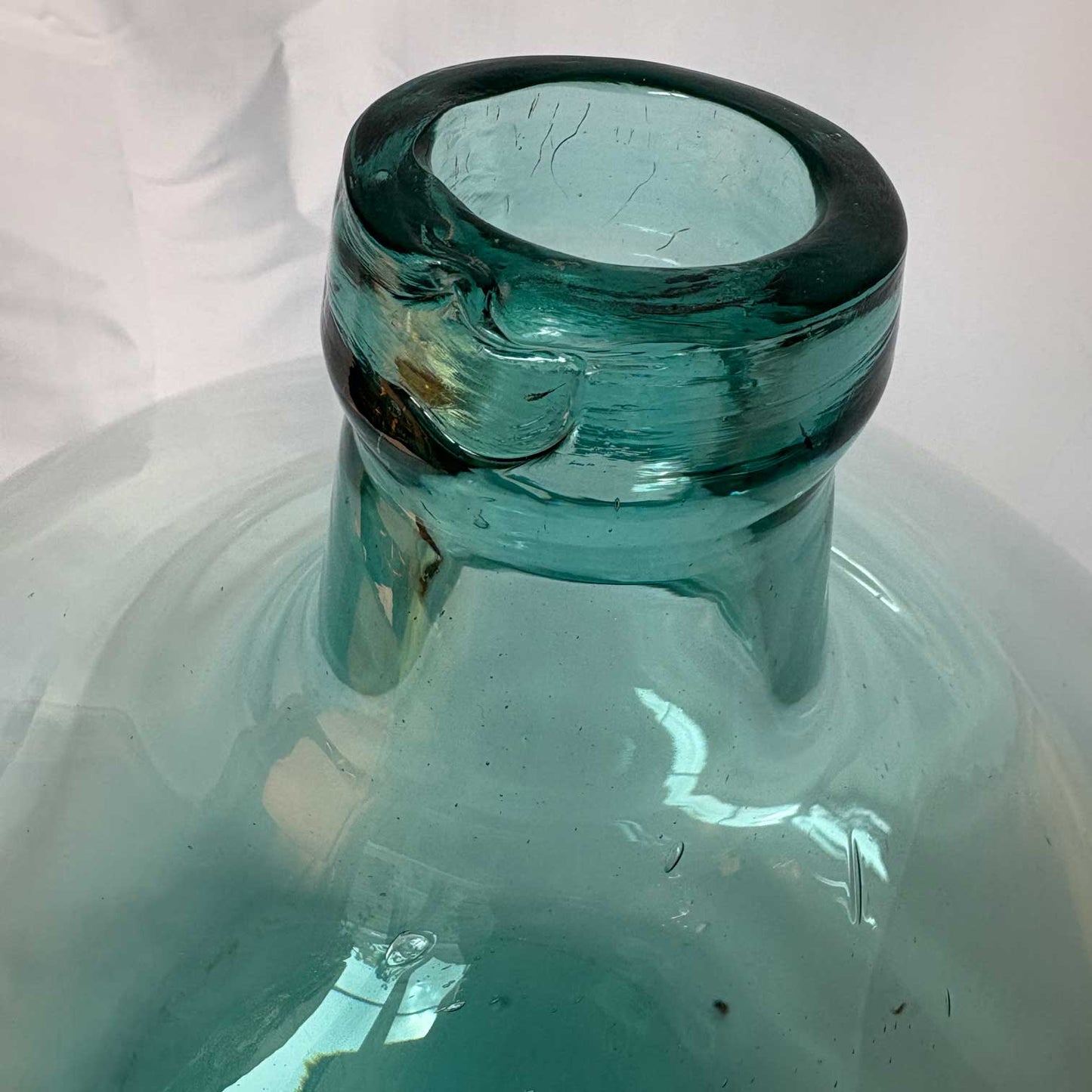 Close-up of a green glass bottle with a black cap on a white background