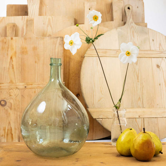 Clear glass bottle with white flowers on a wooden surface