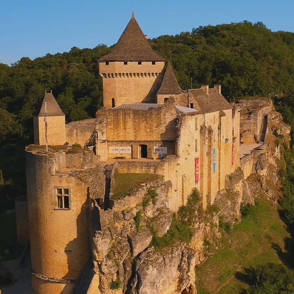 Medieval castle perched on a cliff with greenery around