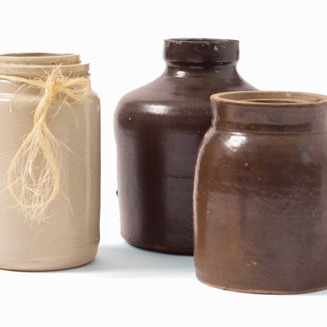 Three ceramic jars in different colors on a white background