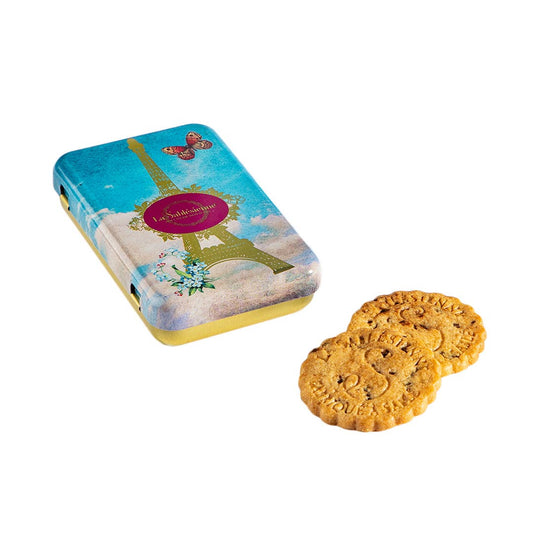 Cookies in front of a decorative cookie tin with Eiffel Tower design on a white background