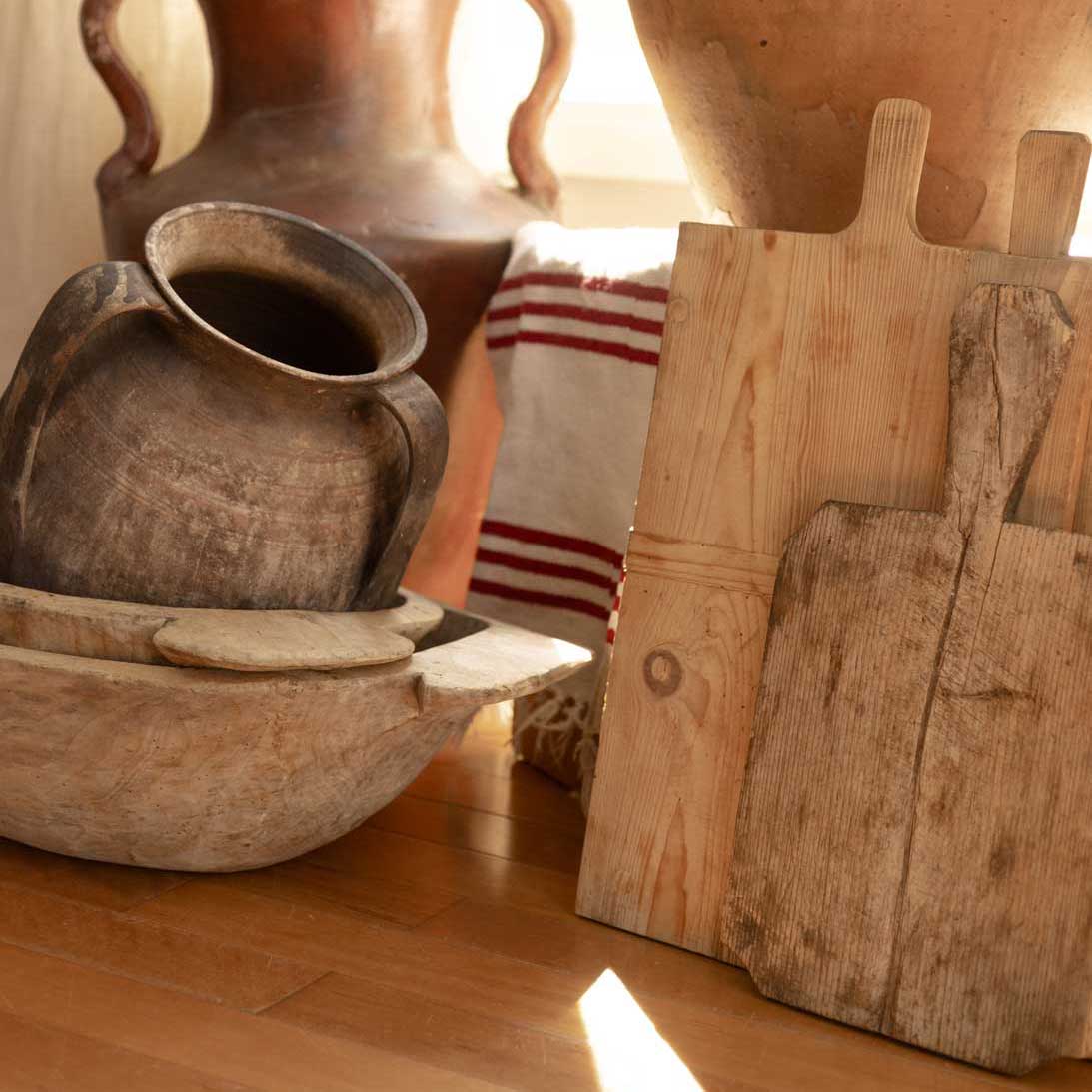 Vintage wooden kitchenware including bowls and a cutting board on a wooden floor.