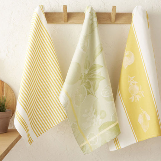 Three towels with different patterns hanging on a wooden rack against a light background.
