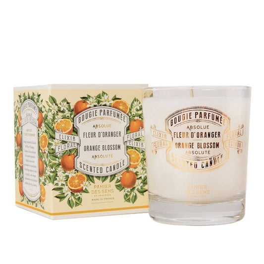 Scented candle with packaging featuring orange blossoms and floral design on a white background