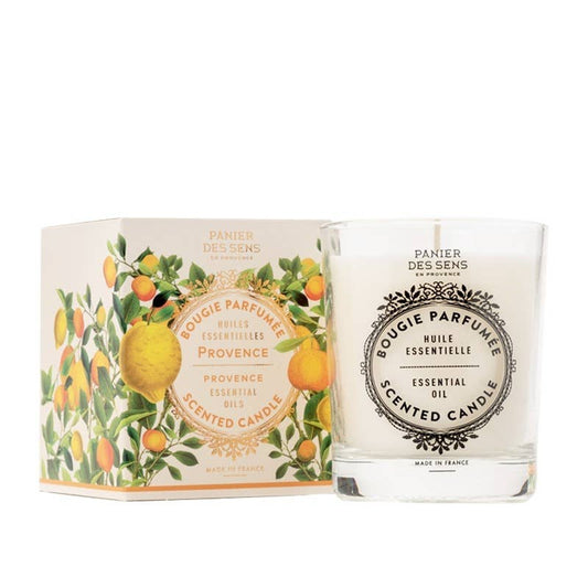 Scented candle with packaging featuring lemons and oranges on a white background