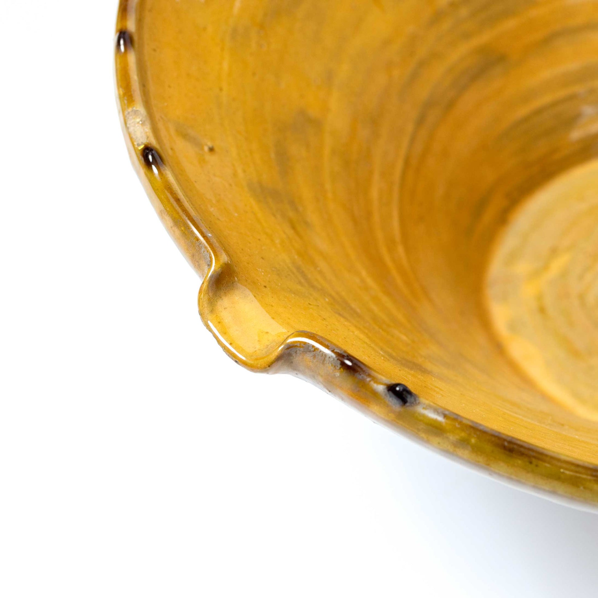 Close-up of a yellow ceramic bowl with a handle on a white background