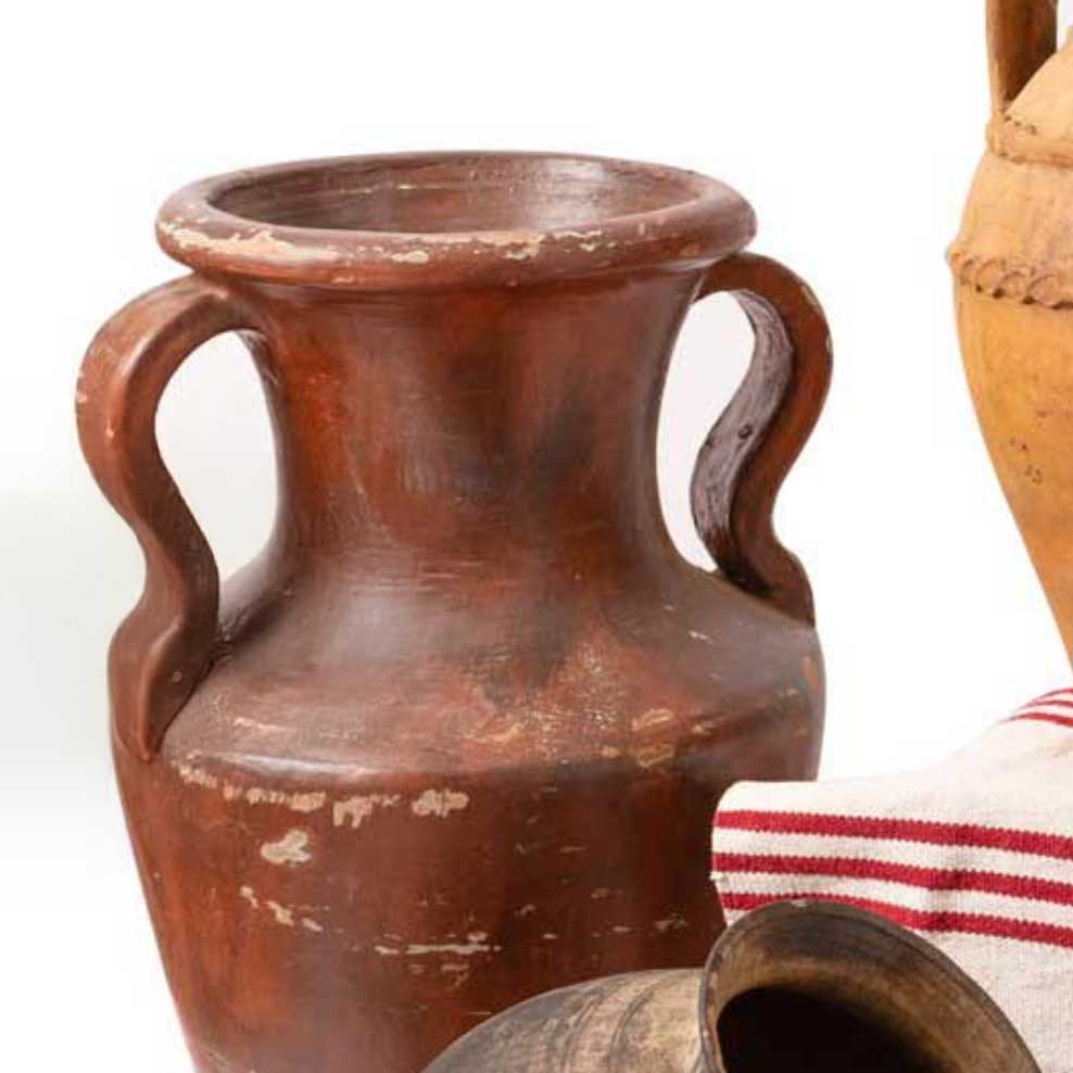 Brown ceramic vase with handles on a white background