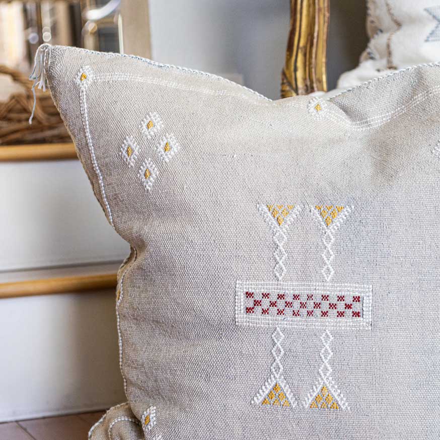 Decorative pillow with embroidered patterns on a neutral background